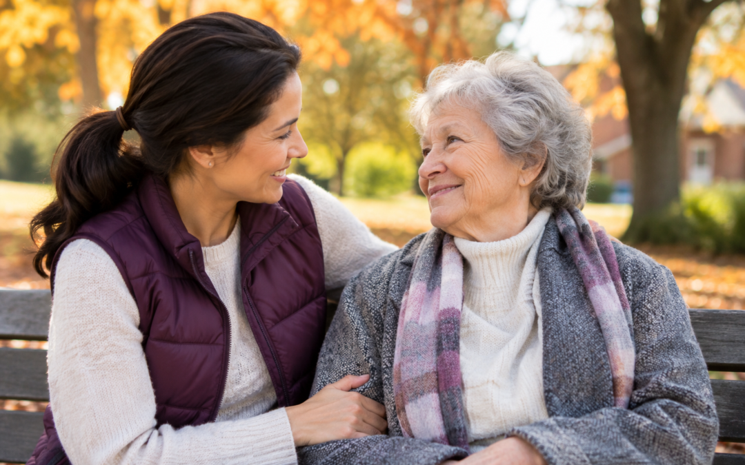 Older adult woman enjoying autumn companionship with a younger woman on a park bench